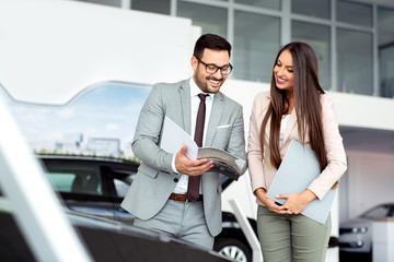 Wall Mural - Professional salesperson selling cars at dealership to buyer