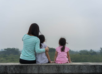 Family Asian mom and Daughter Sitting on a dam