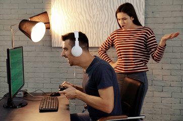 Young couple having conflict while playing video game at home