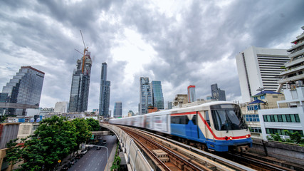 Wall Mural - Sky train, mass transportation pass through skycrapers business building in central business district of Bangkok, Thailand