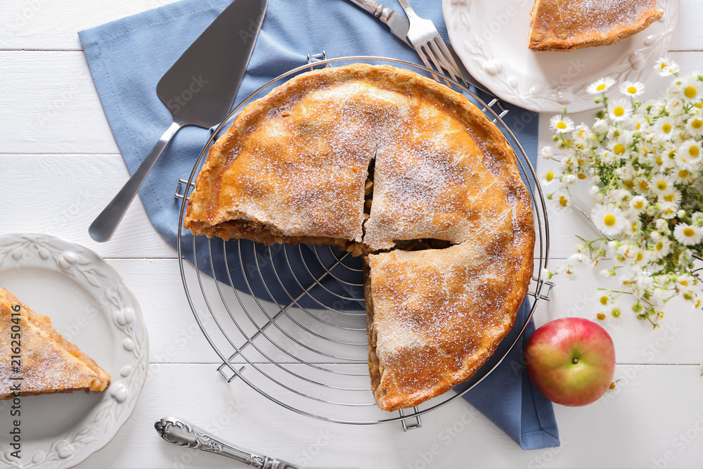 Cooling rack with freshly baked tasty apple pie on table