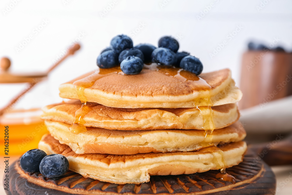 Tasty pancakes with blueberries on board, closeup