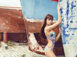 © Acronym - Beautiful, sensual and sexy fashion model posing in front of old rusty boat.