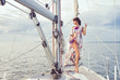 © Acronym - Beautiful fashion model posing on a sailing boat in swimsuit.