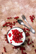 Zdrowy deser z organicznymi czerwonymi porzeczkami, świeżym jogurtem z płatkami kukurydzianymi. Dietetyczne śniadanie na drewnianym tle. 