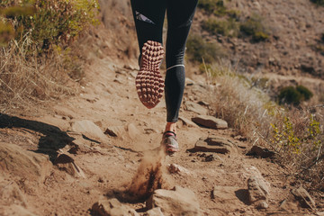 Woman runner running on mountain trail