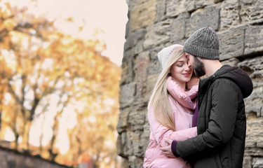 Poster - Young romantic couple near stone wall outdoors