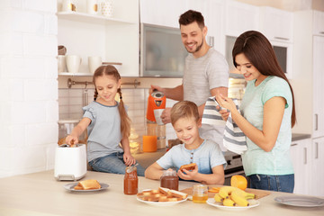 Happy family having breakfast with toasts in kitchen