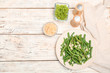 © New Africa - Plate with tasty green beans and almonds on wooden table, top view