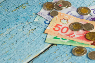 Canadian dollars and coins on the wooden background