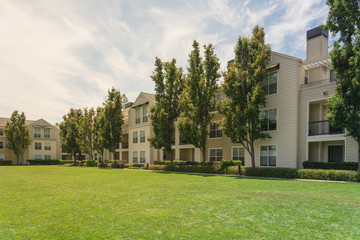 Wall Mural - Standard view apartment building complex with grassy backyard in Palo Alto, California, USA. Summer cloud blue sky