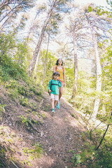 Wall Mural - A woman and her child walk along a forest trail.