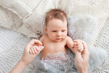 Mother holding hands of newborn baby son