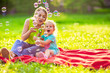 © Lucky Fenix - Happy family in park -Female child blows soup foam and make bubbles with her mother in nature.