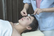 © Sirirat Makprasert - The physiotherapist is doing acupuncture on the face of a female patient. Patient is lying down on a bed; Acupuncture treatment.