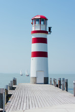 View Of Lighthouse And Pier Against Blue Sky