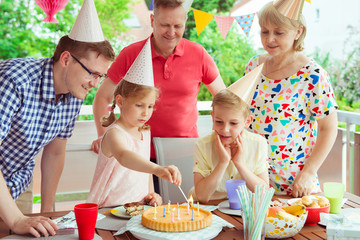 Wall Mural - Colorful portrait of happy family celebrate birthday and grandparents blows candles with children