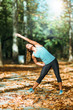 © Microgen - Woman stretching in the park, in the fall.