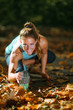 © Microgen - Woman stretching in the park, in the fall.