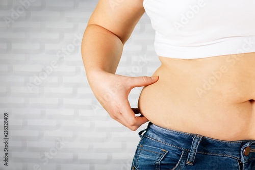 Cuadros en Lienzo Woman's hand holding excessive belly fat