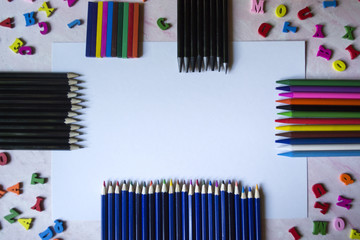 Wall Mural - Multicolor letters and set of pencils on the table. Colorful wooden alphabet and pencils on a table.