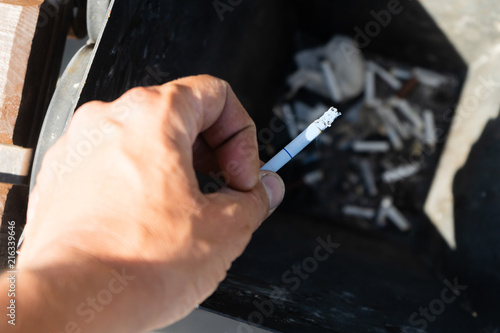 Fotografia, Obraz Smoking a cigarette, Hand finishing a cigarette in an ashtray