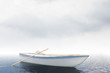Loney white boat in an open sea, cloudy day