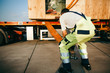 Arbeiter sichert einen schweren Container für den Transport 