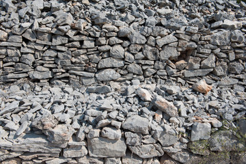 Wall Mural - Old grey stone dry wall as background. Stone surface. Dry stack, traditional construction