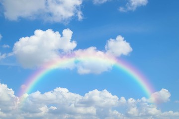 cloudscape with blue sky and white clouds rainbow