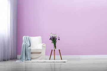 Poster - stylish comfortable armchair near color wall