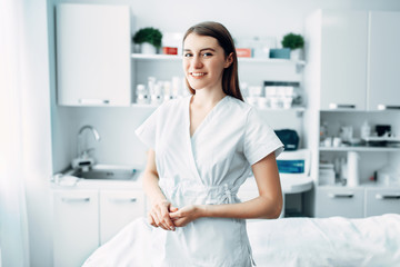 Young female beautician in cosmetology cabinet