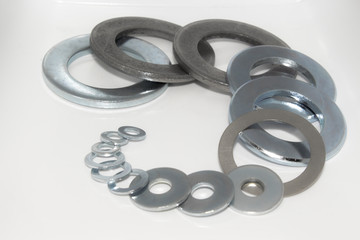 Variety of industrial galvanized steel washers on white background