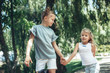 © Yakobchuk Olena - Full length of delighted girl holding sister hand outside. They are strolling outdoors with delight enjoying summer time