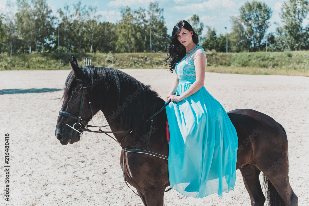Beautiful young woman in long blue dress riding a horse in countryside. Portrait of a dark horse and woman. Attractive girl riding on horse rural location Stock Photo | Adobe Stock Beautiful young woman in long blue dress riding a horse in countryside. Portrait of a dark horse and woman. Attractive girl riding on horse rural location Stock Photo | Adobe Stock