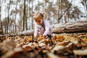 Beautiful and happy little girl enjoying in autumn park.