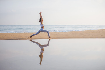 Canvas Print - Caucasian woman practicing yoga at seashore of tropic ocean