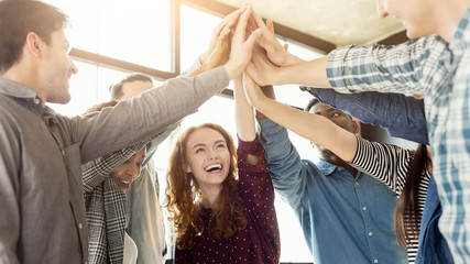 Team of united coworkers standing with hands together