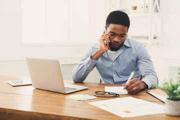 Wall Mural - Young black businessman talking on mobile phone