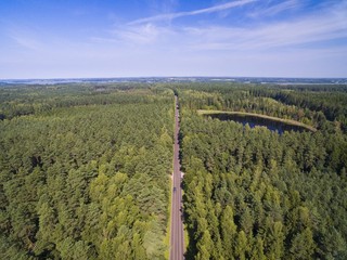 Wall Mural - Aerial view of straight road through the mixed forest by the lakeshore, Mazury, Poland