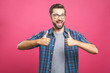 © denis_vermenko - Portrait of young man in glasses showing thumbs up isolated over pink background
