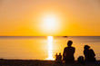 © Korradol - Silhouette of people sit on the beach and enjoying the sunset.