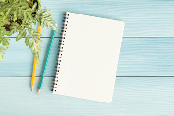 Wall Mural - blank notebook with and pencil on blue background,flat lay photo of notebook for your message