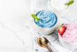 Healthy diet summer dessert, vanilla and berry frozen yogurt or  soft ice cream in white bowls, white marble background copy space