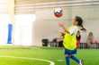 © junce11 - Little Asian girl is training in indoor soccer field