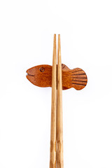 pair of wood chopsticks with wood holder isolated on a white background