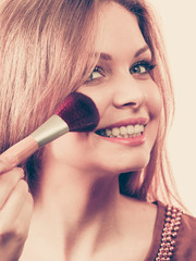 Smiling woman holding make up brush