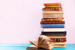 © neirfy - Pile of vintage books on blue wooden shelf, copy space on pink wall background