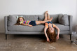 © Lisa Tichané - Playful little girls lying on grey sofa