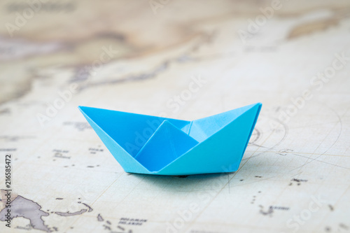 Blue Origami Paper Ship Or Boat On Vintage Ocean Map With